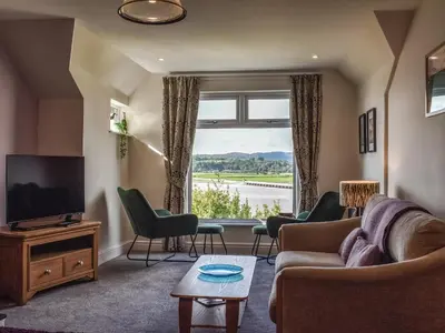a living room with a couch and chairs and a window at Ted's Place in Arnside