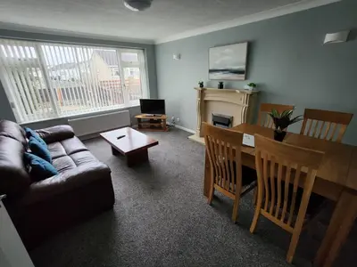 a living room with a couch and a table at Quiet Ground Floor apartment with parking in Morecambe