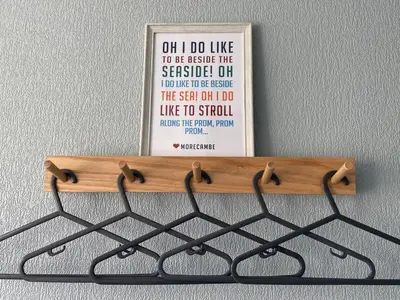 a sign hanging on a wall with a shelf at Quiet Ground Floor apartment with parking in Morecambe
