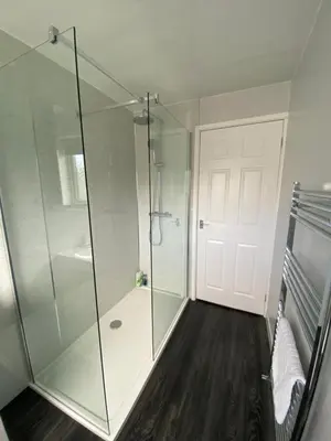 a bathroom with a shower and a glass door at Quiet Ground Floor apartment with parking in Morecambe