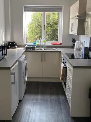 a kitchen with a sink and a washing machine at Quiet Ground Floor apartment with parking in Morecambe