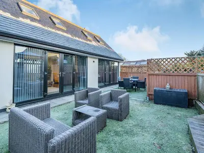 an outdoor patio with wicker chairs and tables at Ferndale Bungalow in Hambleton