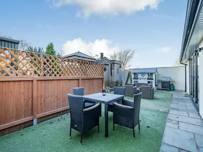 a patio with a table and chairs and a fence at Ferndale Bungalow in Hambleton
