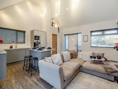 a living room with a couch and a kitchen at Ferndale Bungalow in Hambleton
