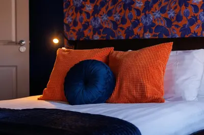 a blue pillow sitting on top of a bed with pillows at Hornsey House - Air Host & Stay - 5 Bedrooms Sleeps 10 in Liverpool