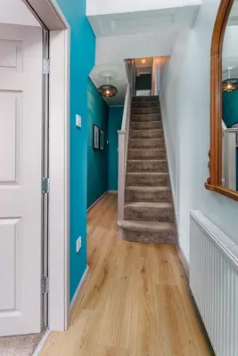 a hallway with blue walls and stairs in a house at Hornsey House - Air Host & Stay - 5 Bedrooms Sleeps 10 in Liverpool
