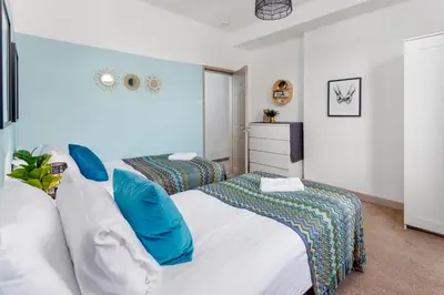 a bedroom with two beds with blue pillows at Hornsey House - Air Host & Stay - 5 Bedrooms Sleeps 10 in Liverpool