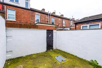 a garage with a white fence and a black door at Trendy house, close to stadiums, free wifi and car park in Liverpool