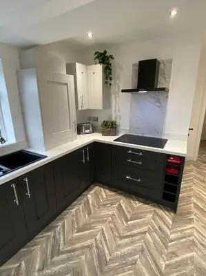 a kitchen with black and white cabinets and a wooden floor at Wharfedale Lodge- Bungalow-3 Bed, 2 bath, Amazing! in Thornton
