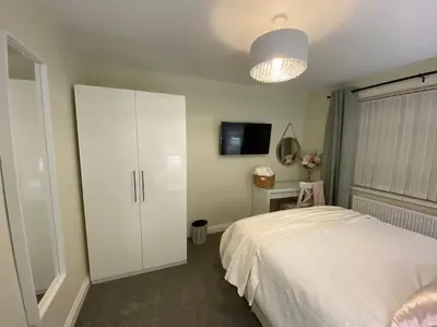 a bedroom with a white bed and a white cabinet at Wharfedale Lodge- Bungalow-3 Bed, 2 bath, Amazing! in Thornton