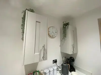 a kitchen with white cabinets and a clock on the wall at Wharfedale Lodge- Bungalow-3 Bed, 2 bath, Amazing! in Thornton