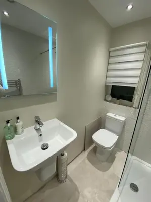a bathroom with a sink and a toilet and a mirror at Wharfedale Lodge- Bungalow-3 Bed, 2 bath, Amazing! in Thornton