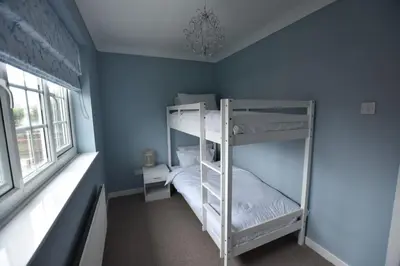 a bedroom with two bunk beds in a blue wall at The Nutshell in Southport