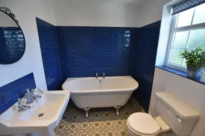 a bathroom with a tub and a toilet and a sink at The Nutshell in Southport