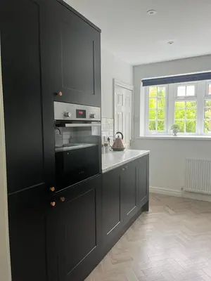 a kitchen with black cabinets and a microwave at The Nutshell in Southport