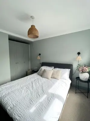 a bedroom with a large bed with a white bedspread at The Cottage, a perfect getaway! in Southport