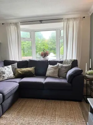a living room with a blue couch in front of a window at The Cottage, a perfect getaway! in Southport