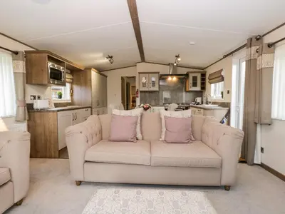 a living room with a couch and a kitchen at Hudson's Hideaway in Carnforth