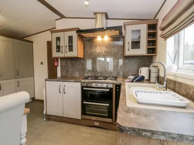 a kitchen with a stove and a sink at Hudson's Hideaway in Carnforth