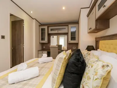 a bedroom with a large bed with a couch at Hudson's Hideaway in Carnforth