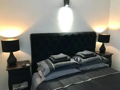 a bedroom with a bed with pillows and two lamps at 77 Park Road Apartments in Blackpool