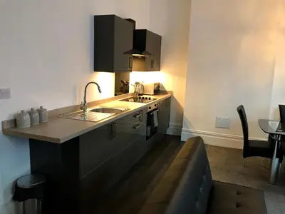 a kitchen with two sinks and a couch at 77 Park Road Apartments in Blackpool