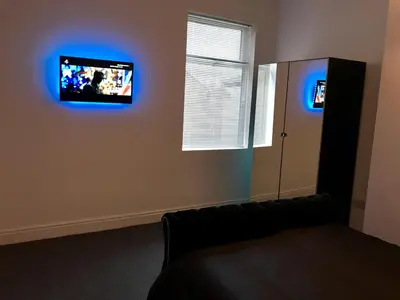 a living room with a couch and a tv on the wall at 77 Park Road Apartments in Blackpool