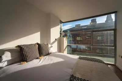 a bedroom with a bed and a large window at Free Parking Modern Balcony 2 Bed City Centre in Liverpool