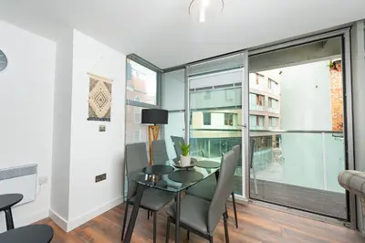 a dining room with a table and chairs and a large window at Free Parking Modern Balcony 2 Bed City Centre in Liverpool