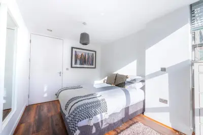 a white bedroom with a bed and a window at Free Parking Modern Balcony 2 Bed City Centre in Liverpool