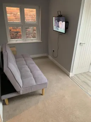 a living room with a couch and a tv at Town Centre Getaway in Southport
