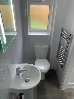 a bathroom with a toilet and a sink and a window at Town Centre Getaway in Southport
