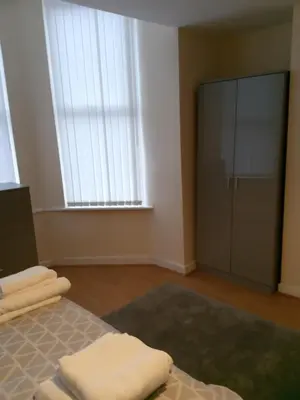 a bedroom with a bed and a large window at Sandringham House in Liverpool