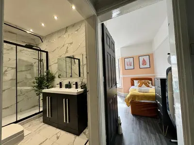 a bathroom with a sink and a bedroom at 4 Bedroom Anfield House, 7 beds, Free Parking, Garden - 5 mins to LFC, 15 mins to City Centre in Liverpool