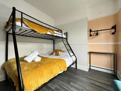 a bedroom with two bunk beds with a dog laying on the bed at 4 Bedroom Anfield House, 7 beds, Free Parking, Garden - 5 mins to LFC, 15 mins to City Centre in Liverpool