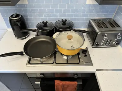 a pot on a stove with several pots and pans at 4 Bedroom Anfield House, 7 beds, Free Parking, Garden - 5 mins to LFC, 15 mins to City Centre in Liverpool