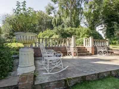 a group of chairs and a vase on a patio at Millwood Manor in Barrow in Furness