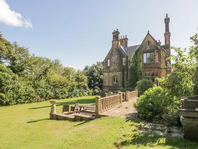 an old house with a bench in front of it at Millwood Manor in Barrow in Furness