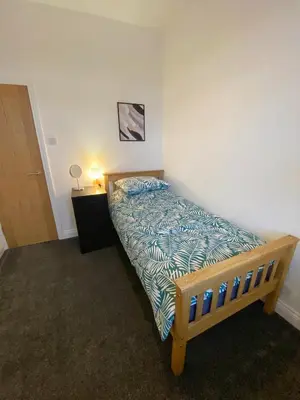 a bedroom with a bed in a room at A spacious & modern 3-bed home in Blackburn