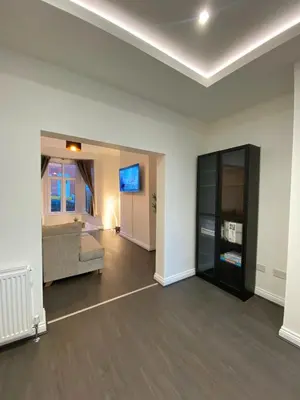 an empty living room with a couch and a tv at A spacious & modern 3-bed home in Blackburn