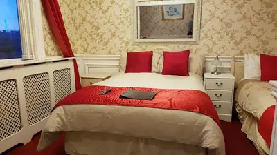 a bedroom with a bed with a red blanket at The Brema Hotel in Blackpool