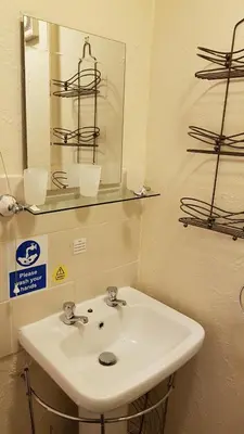 a bathroom with a white sink and a mirror at The Brema Hotel in Blackpool
