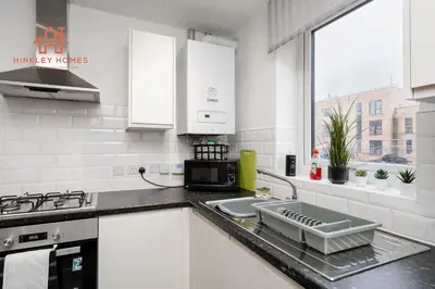 a white kitchen with a sink and a microwave at Stylish 3-Bed Sleeps 8 Liverpool free wifi carpark By Hinkley Homes Short Lets & Serviced Accommodation in Liverpool