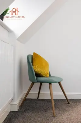a green chair with a yellow pillow in a room at Stylish 3-Bed Sleeps 8 Liverpool free wifi carpark By Hinkley Homes Short Lets & Serviced Accommodation in Liverpool