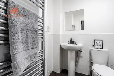 a white bathroom with a sink and a toilet at Stylish 3-Bed Sleeps 8 Liverpool free wifi carpark By Hinkley Homes Short Lets & Serviced Accommodation in Liverpool