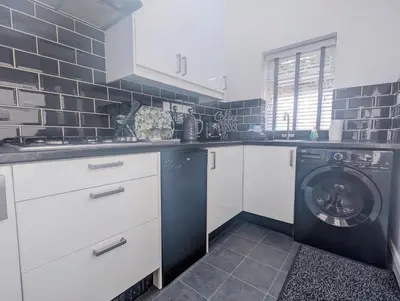 a kitchen with a washing machine and a washer at 3 Bed City Home - South Facing Patio - 4-5 Beds in Lancaster
