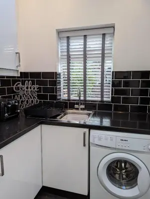 a kitchen with a sink and a washing machine at 3 Bed City Home - South Facing Patio - 4-5 Beds in Lancaster