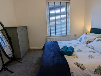 a bedroom with a bed with blue shoes on it at 3 Bed City Home - South Facing Patio - 4-5 Beds in Lancaster