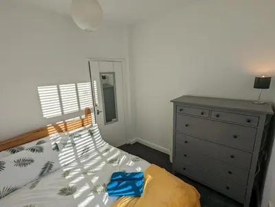 a bedroom with a bed and a dresser and a mirror at 3 Bed City Home - South Facing Patio - 4-5 Beds in Lancaster