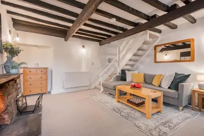 a living room with a couch and a table at Bluebell Wood Cottage - with hot tub in Cartmel